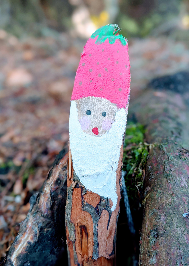 Painted dwarf with a pink hat on a branch
